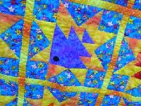 This fish is really purple!  A deep purple.  Star is Golden Yellow and background is bright blue.  The quilt is actually all finished!
